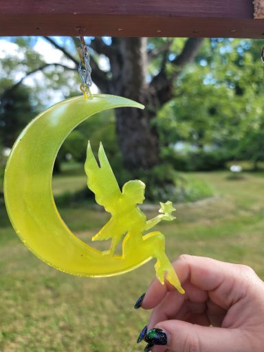 Yellow fairy sitting on a yellow cresent moon