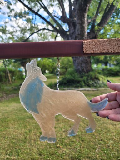 Brown wolf with blue mane, tail and paws baying